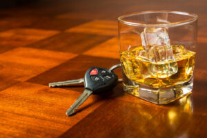 Car keys next to a glass of whiskey