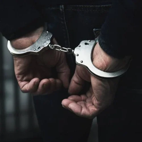 a closeup of a man's hands in handcuffs