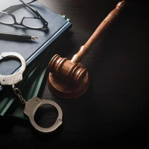 handcuffs next to a gavel representing criminal law including felonies and misdemeanors