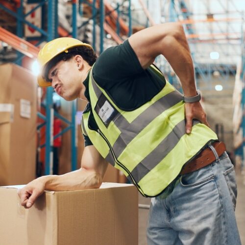 Logistics, loader and man with backache in warehouse, injury and stock distribution or supply chain. Shipping, joint pain and person with muscle tension, workplace accident and safety risk in factory