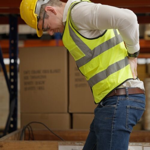 Male warehouse engineer manager suffering from back injury during checking stock working at warehouse factory, Storage worker having back pain at work