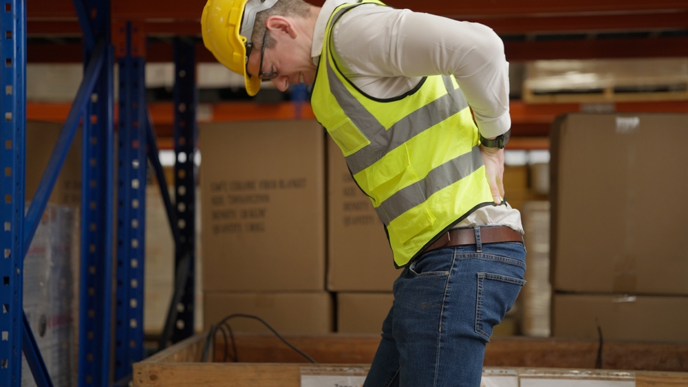 Male warehouse engineer manager suffering from back injury during checking stock working at warehouse factory, Storage worker having back pain at work
